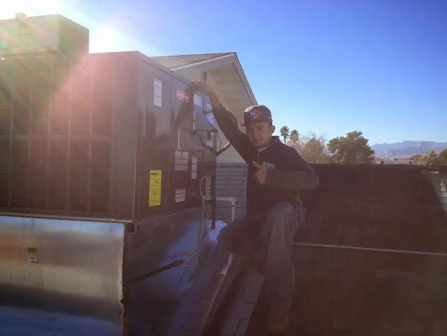 HVAC technician performing Air Duct Cleaning on a rooftop unit in Blackhawk